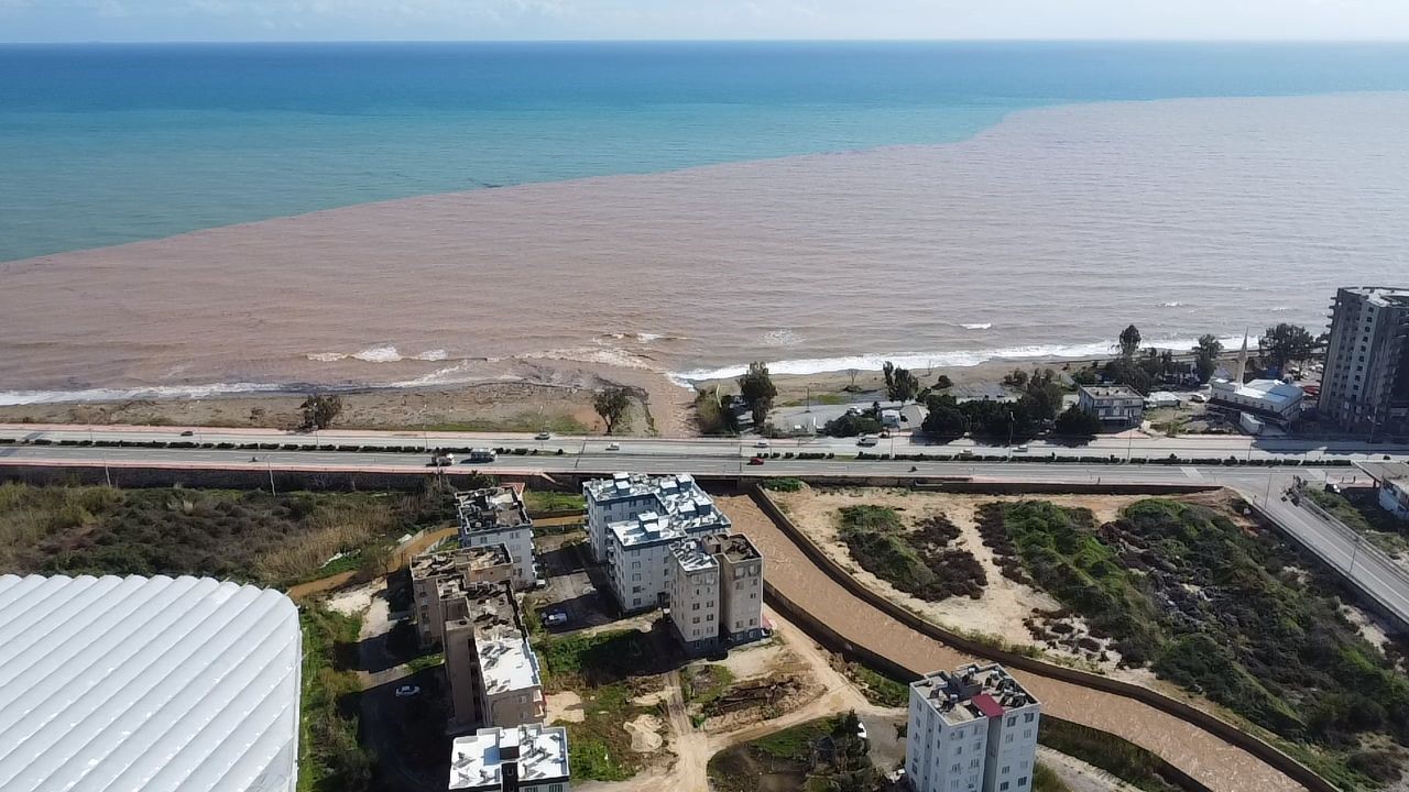 DERELERDEN AKDENİZ’E AKAN SEL SULARI KIYI ŞERİDİNİ ÇAMURA BÜRÜDÜ